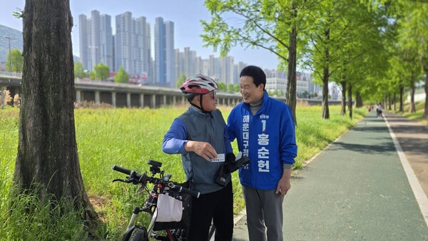 오는 6.3 지방선거에 출마한 더불어민주당 홍순헌 부산 해운대구청장 후보가 선거운동 현장에서 만난 주민과 대화를 나누고 있다. /홍순헌 페북