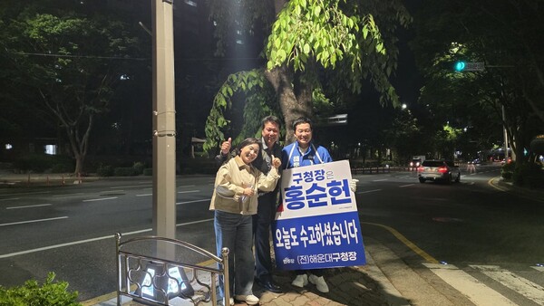 오는 6.3 지방선거에 출마한 더불어민주당 홍순헌 부산 해운대구청장 후보가 선거운동 현장에서 만난 주민들과 기념촬영을 하고 있다. /홍순헌 페북