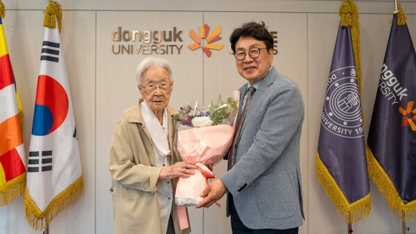 류완하 총장이 김달수 불지에게 감사의 뜻을 꽃다발에 담아 전달했다. 사진=동국대(포인트경제)