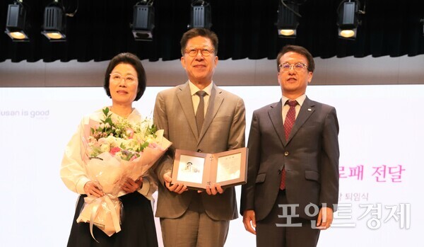 박형준 부산시장(가운데)이 배우자 조현 여사(왼쪽), 김경덕 행정부시장과 26일 오후 3시 시청 1층 대강당에서 열린 퇴임식에서 감사패를 전달받은 뒤 기념촬영을 하고 있다. (사진=윤선영) ⓒ포인트경제