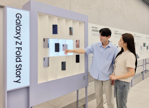 삼성전자 모델이 '폴더블 헤리티지'의 '갤럭시 폴드·플립 스토리' 섹션에서 역대 갤럭시 폴더블 라인업을 확인하는 모습 /삼성전자