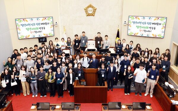 29일 밀양시청 실무수습 임용자들이 밀양시의회 본회의장을 방문해 기념촬영을 하고 있다. /밀양시의회