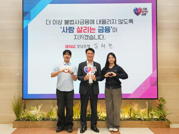BNK경남은행 김태한 은행장(가운데)이 남녀 직원과 함께 ‘사람 살리는 금융 릴레이 캠페인’에 참여한 뒤 기념촬영을 하고 있다. /BNK경남은행