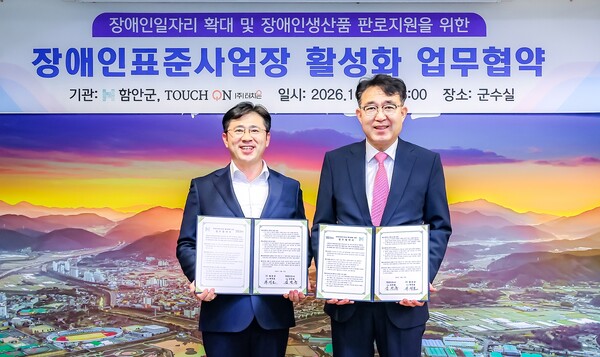 차석호 함안군수(오른쪽)와 김정훈 (주)터치온 대표가 27일 군청 군수실에서 업무협약을 체결한 뒤 기념촬영을 하고 있다. /함안군